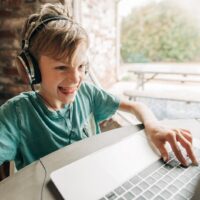 Boy playing game on laptop